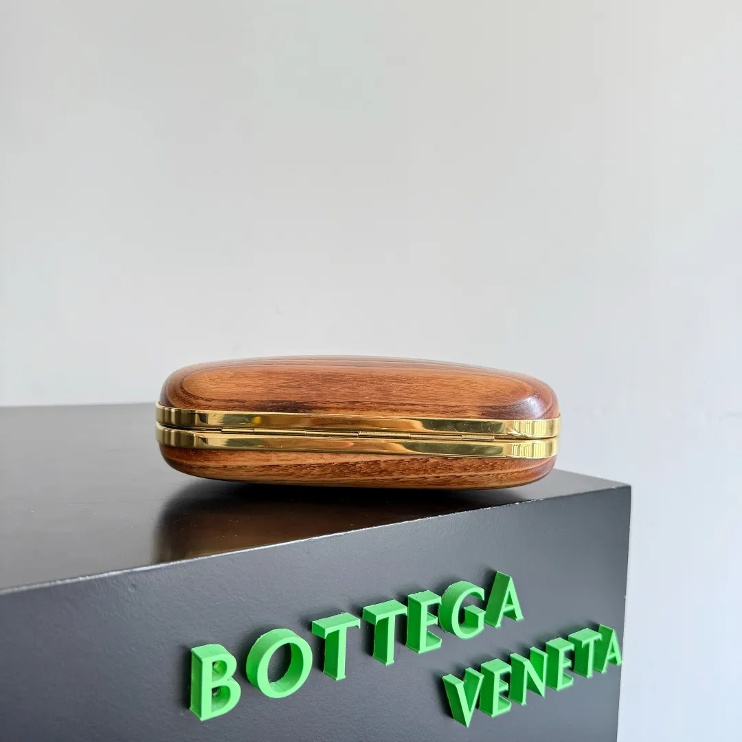 Batch 2720 BOTTEGA VENETA2025 new kont evening bag When the natural texture of wood meets the brass edge, the BV evening bag becomes a work of art in the fashion world. Every wood grain is a mark of time, delicate and unique. The brass metal buckle is embellished like stars, and opening it is full of ritual. It is the focus of the dinner party, and can easily store your exquisite small things. The warmth of wood and the cold and cool collision of metal tell the niche light luxury style in every gesture, allowing you to shine with a unique attitude in every feast. Style number: 804292 (717622) Color: maroon Size: 20.5*6*12.5cm